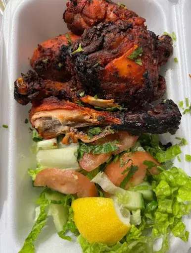 Tandoori chicken with fresh salad in a takeout container at Lovely Sweets Calgary